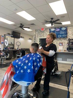 My son getting his hair cut by Maria.