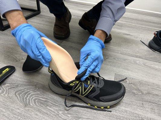 Bio Custom Foot Orthotics being fitted to patient's shoe.