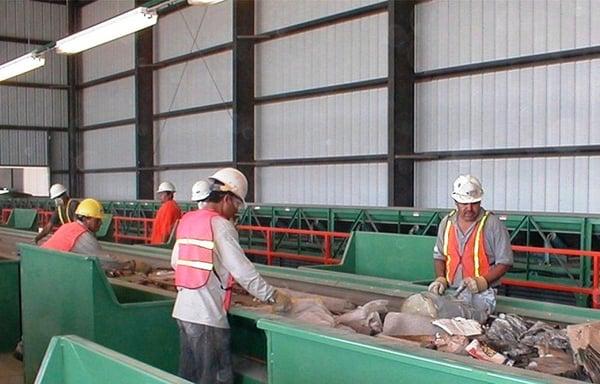 Workers are picking recyclable material off the line.