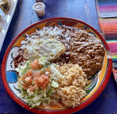 Red Chile Enchiladas with rice and beans and fried egg on top.