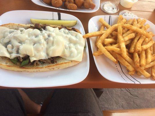 Philly steak and cheese sub and french fries.