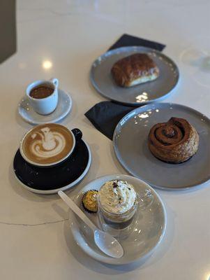 Pastries: from top to bottom Chocolate croissant  Artisan Cinnamon bun   Coffee: from top to bottom  Macchiato  Latte Café Bonbon