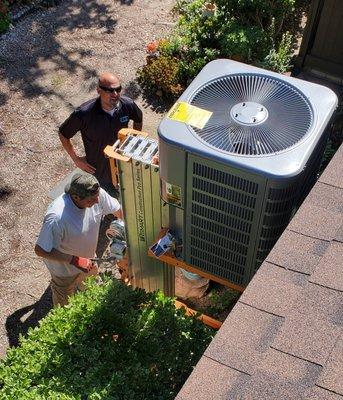 Installing a new condenser onto roof.