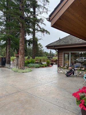 View showing entrance to restaurant on right side, patio by pine trees.