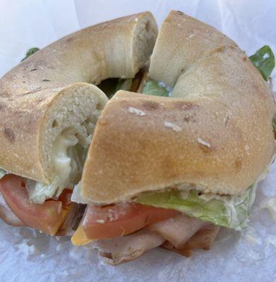 Turkey, lettuce, tomato, and cheese on plain bagel