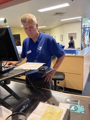 Rex coordinating at the front desk & Tarez (seen in the background, working).