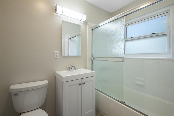 Full size bathtub with glass sliding doors.   LED lighting