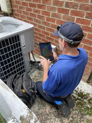 Our tech doing an inspection on an outdoor HVAC unit.