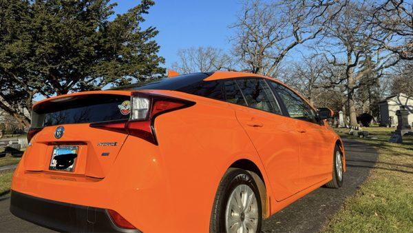 Orange car with a fresh paint job.