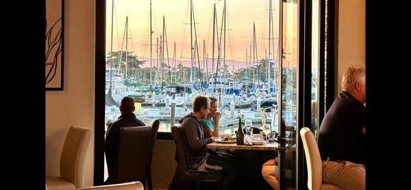 View from interior looking out to covered patio and harbor.