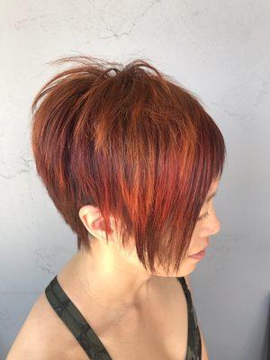 Beautiful Sunset inspired hair color with asymmetrical razor cut. Owner By Ken bradshaw