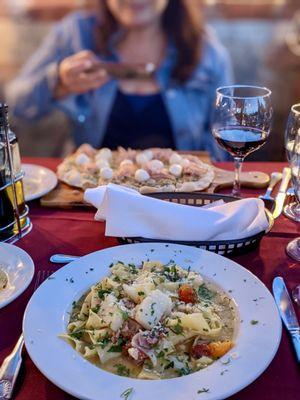 Scallops and pappardelle with Roman pizza in the background.