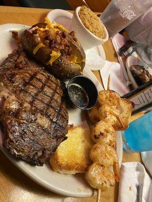 Ribeye and shrimp Texas combo with a loaded baked potato and seasoned rice. Blue raspberry lemonade to drink!