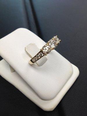 Three stone anniversary ring with extra diamonds down the side.