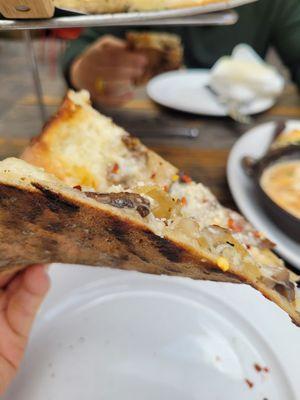 Side view of mushroom thin crust pizza. Had a nice char and texture.