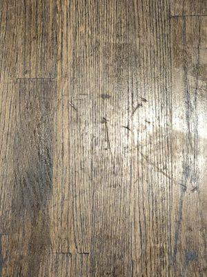 Gauges and scratches left on floor after Old Bay stained them to cover damages.