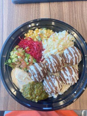 Falafel bowl with hummus, corn, cabbage, and rice.