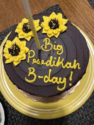 Six inch classic chocolate layer cake with sunflower  decoration from the business's helpful "cake book".