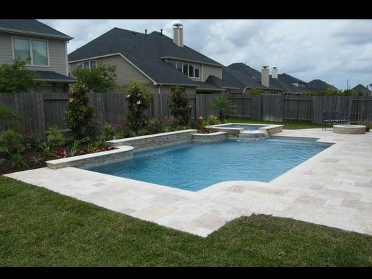 Beautiful pool and spa with travertine paver decking