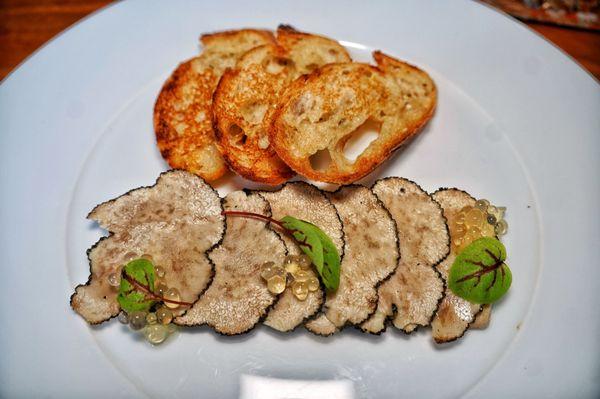 Foie gras topped with black truffles and some buttered baguette