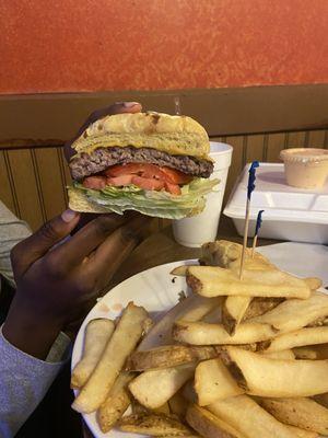 Hamburger with lettuce, tomatoes and Mayo on an onion bun with fries