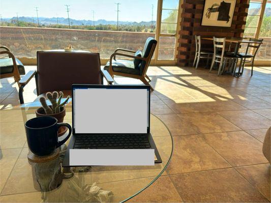 Working at their comfy couch with a beautiful view with a nice cup of coffee