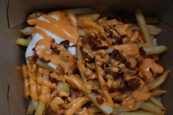 Bacon topped fries with sour cream and house sauce.