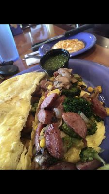 Custom omelet with kielbasa, corn, mushrooms, onion and broccoli with a side of pesto