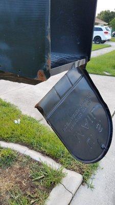 The door of my damaged mailbox that UPS caused leaving it barely on and the frame of the mailbox was extremely wobbly after the hit.