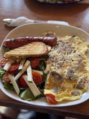 Omelette with side salad and sausage.