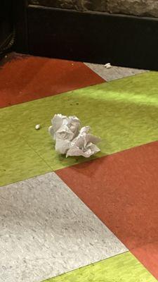 There is trash all over the floor. Including this crumpled napkin.