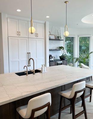 Soft modern kitchen design with wood tones and gold accents