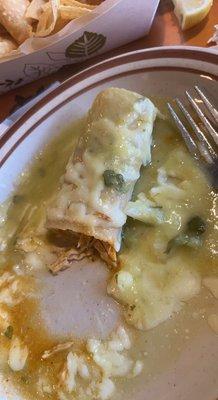 Half eaten chicken enchilada with green sauce