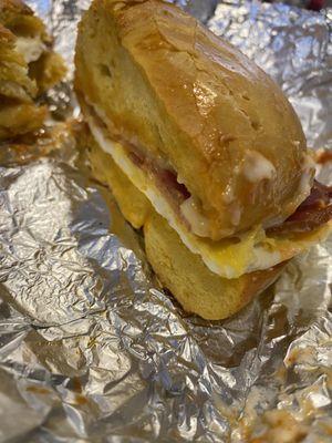 Bacon, American cheese, fried egg on a toasted egg bagel with Sriracha and Mayo