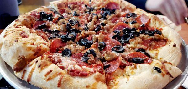 Pizza with pepperoni, sausage and black olives