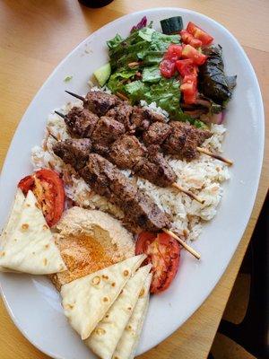 Lamb Kabob Plate with salad, three kabobs, rice, hummus and pita bread, roasted tomatoes, and above average salad.