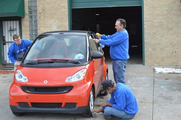 The Step 13 men working hard repairing a donated vehicle.