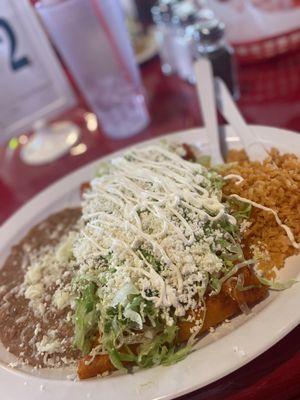 Chicken enchiladas with red sauce, rice and beans