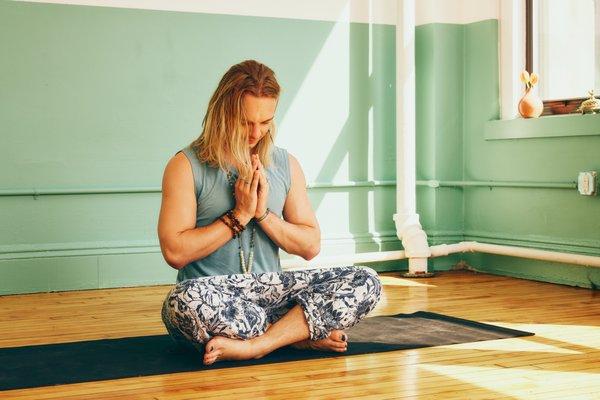 Student in SunRoom in Anjali mudra.