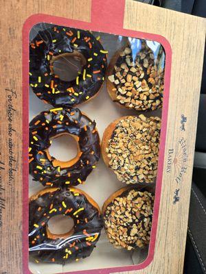 Donuts with chocolate glaze and sprinkles and the donuts with chocolate glaze and chopped peanuts