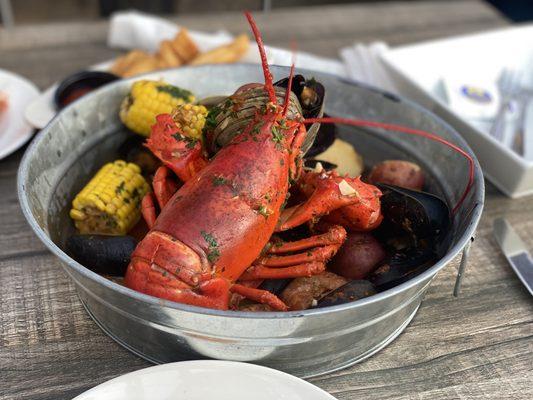 Lobster Boil!  Complete with clams, mussels, potatoes, corn, shrimp and a whole lobster in a delicious garlic & herb brine.