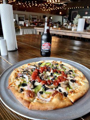 The personal-sized veggie pizza with a bottle of cold root beer was delicious.