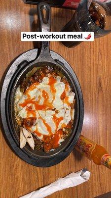 Sizzling Skillet with two over easy eggs and Cholula