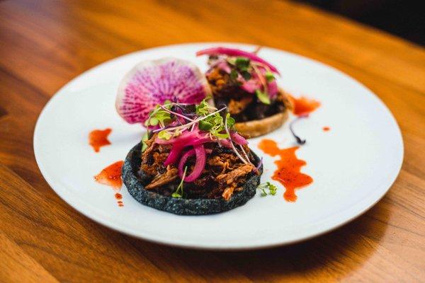 Sopes de Pato Pibil - homemade sopes, duck confit, achiote adobo, black beans, avocado salsa, pickled onion