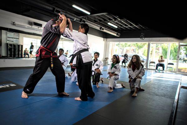 Kids martial arts class teaching front choke.