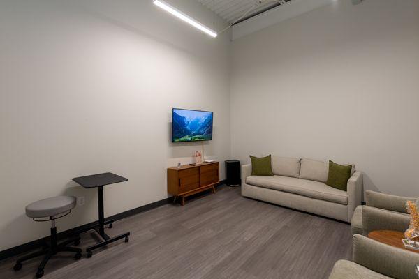 Exam room at Vertrae® with sofa, chairs, and television