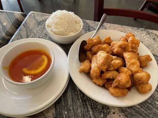 Lemon chicken with white rice and sauce on the side