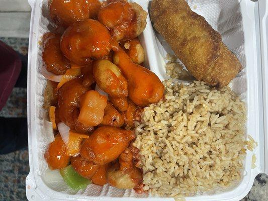 Sweet and sour pork with carrots, onions, peppers, egg roll, fried rice and wonton soup on the side.