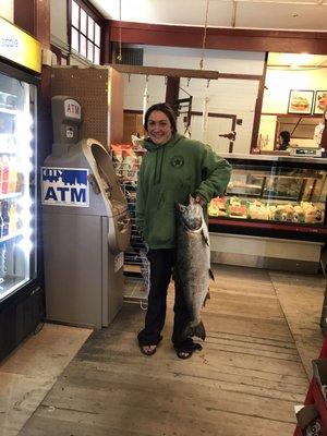 Fisher-woman bringing in her catch of the day (salmon) to the fish counter at Bolina's Mrkt