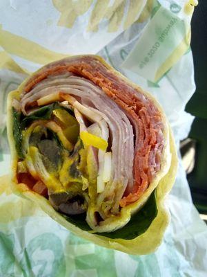 Italian BMT wrap with onions banana peppers olives spinach with hot sauce and mustard cause I like it zingy tasting.